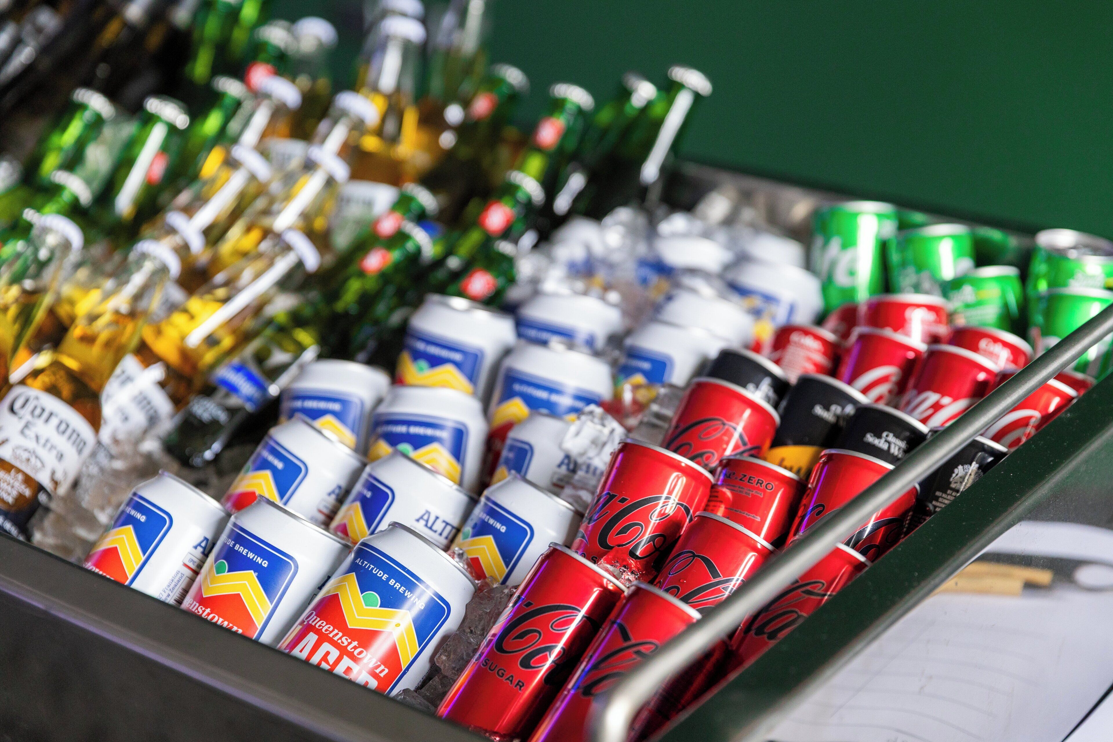 A variety of beverages including cans and bottles, likely in a bar or similar setting.
