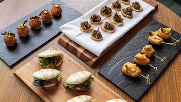 Diversos aperitivos en distintas bandejas de servicio.
