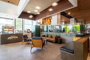 A modern bar area with seating, a counter with a logo, and a view of the outside. - Holiday Inn Queenstown Remarkables Park by IHG (Queenstown)