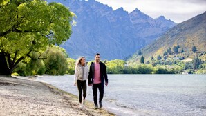 A couple walking along a lakeside path with mountains in the background. - Holiday Inn Queenstown Remarkables Park by IHG (Queenstown)