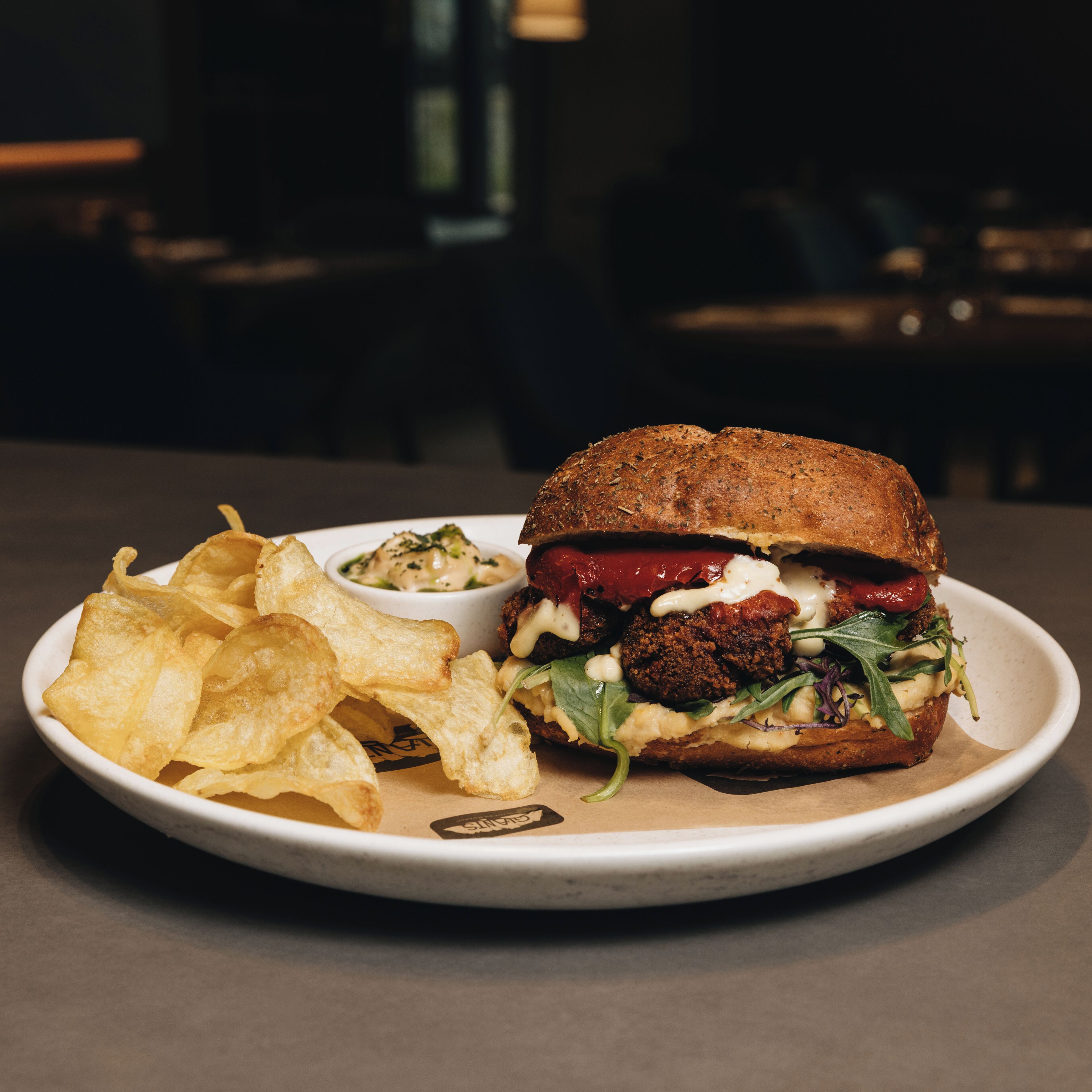 A plate with a burger, fries, and a side dish.