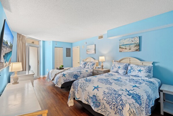 A room with two beds, a TV, a desk, and a window with curtains. - Bay Watch 1432-2BR/2BA Oceanfront Condo in North Myrtle Beach (North Myrtle Beach)
