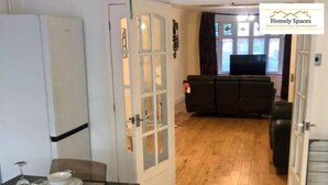 A compact living space with a dining area, a sofa, and a television in the background. - Spacious 3BR Home in Bedford for Big Groups (Bedford)