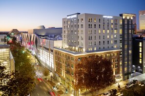 Un hôtel moderne, reconnaissable à son grand panneau « Hyatt Centric », qui présente un mélange d’architecture traditionnelle et contemporaine et qui est situé dans un environnement urbain animé, avec une vue sur la rue et la circulation.