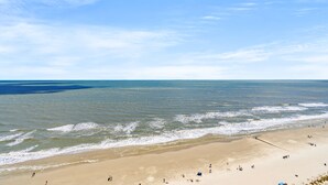 Une plage dotée d’un large rivage sablonneux et d’une mer calme.