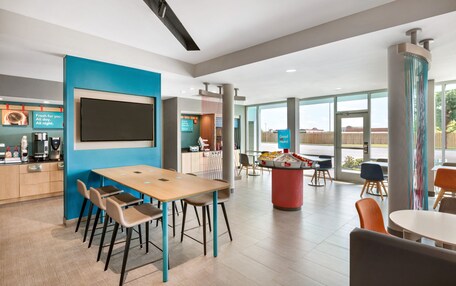 A modern dining area with a large table, chairs, and a coffee station.