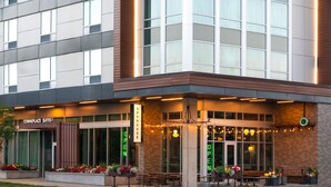 A hotel exterior with a 'Townplace Suites' sign, outdoor seating area, and 'OPEN' signage. - TownePlace Suites by Marriott Rochester Mayo Clinic Area (Rochester)