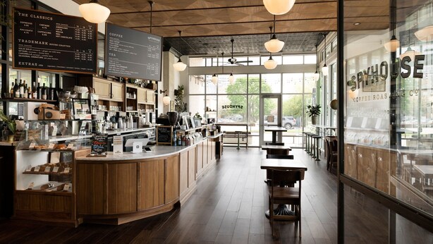 A coffee shop interior with a wooden counter, menu boards, and seating area. - TownePlace Suites by Marriott Rochester Mayo Clinic Area (Rochester)