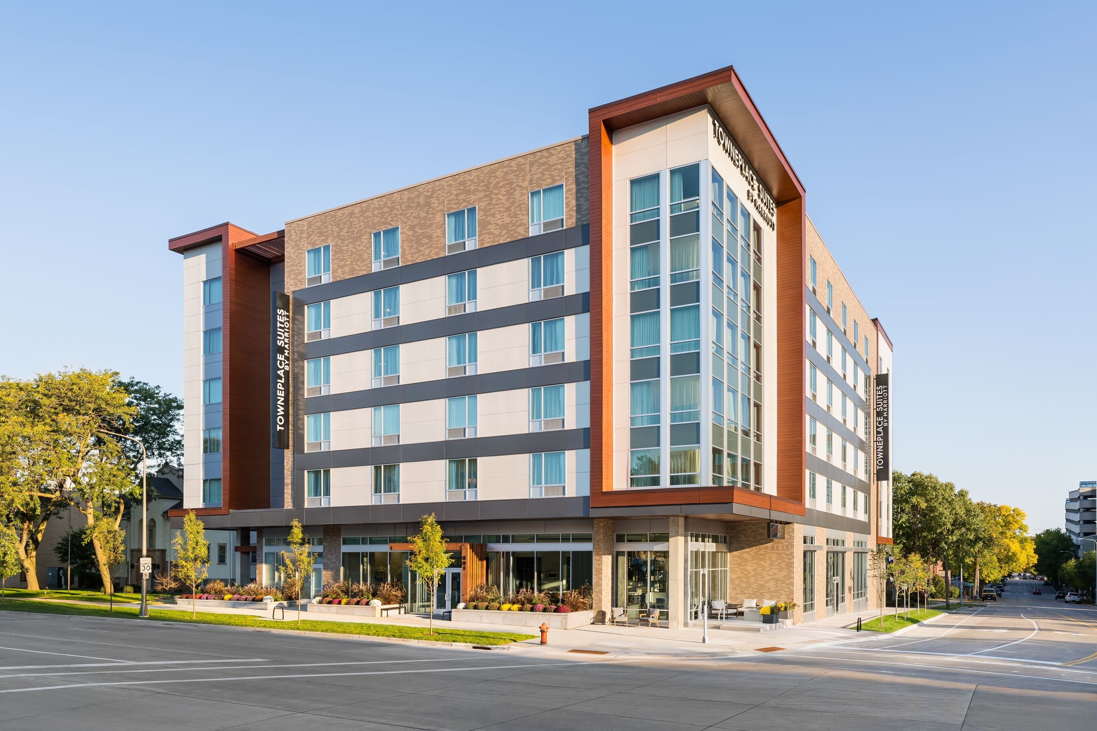 A multi-story hotel with a modern design, featuring a mix of brick and glass facades.