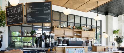 Ein Café mit Holztresen, Speisekarten und diversen Kaffeemaschinen.