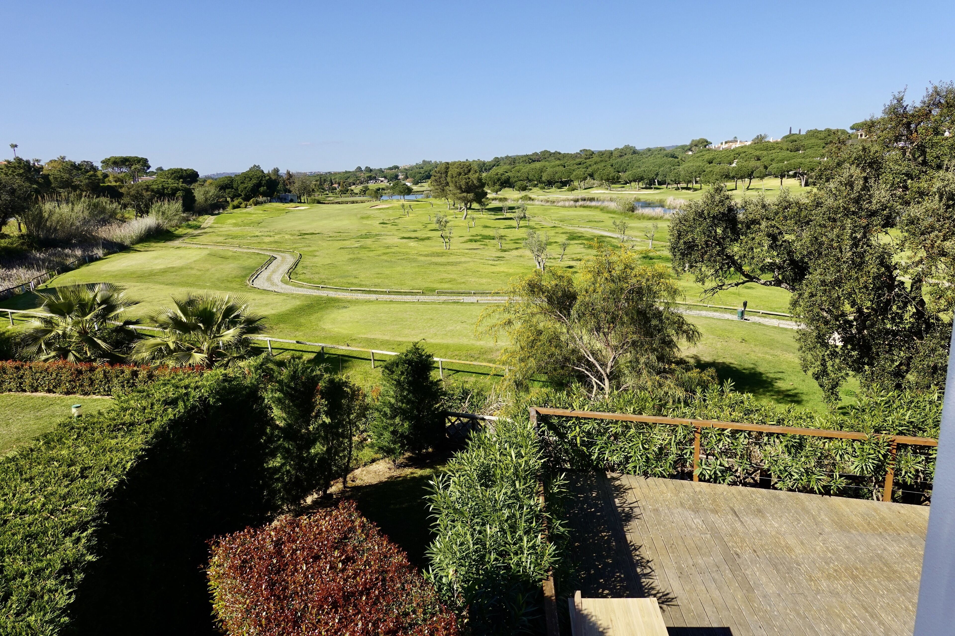 A golf course with a wooden deck and a view of the surrounding landscape.