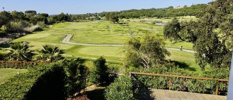 A golf course with a wooden deck and a view of the surrounding landscape.