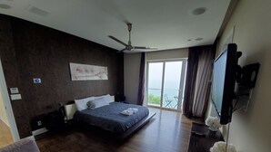 A modern bedroom with a large bed, a ceiling fan, a TV, and a balcony with a view. - Sunset and Serenity (Benton Harbor)