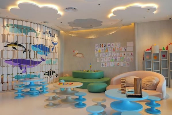 A children's playroom with a wall mural, multiple seating areas, and educational wall decorations. - Courtyard by Marriott Phuket Town (Phuket)