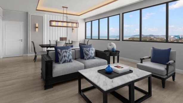 Un salon moderne comprenant un canapé, des fauteuils, une table basse et un coin repas avec une table et des chaises.
