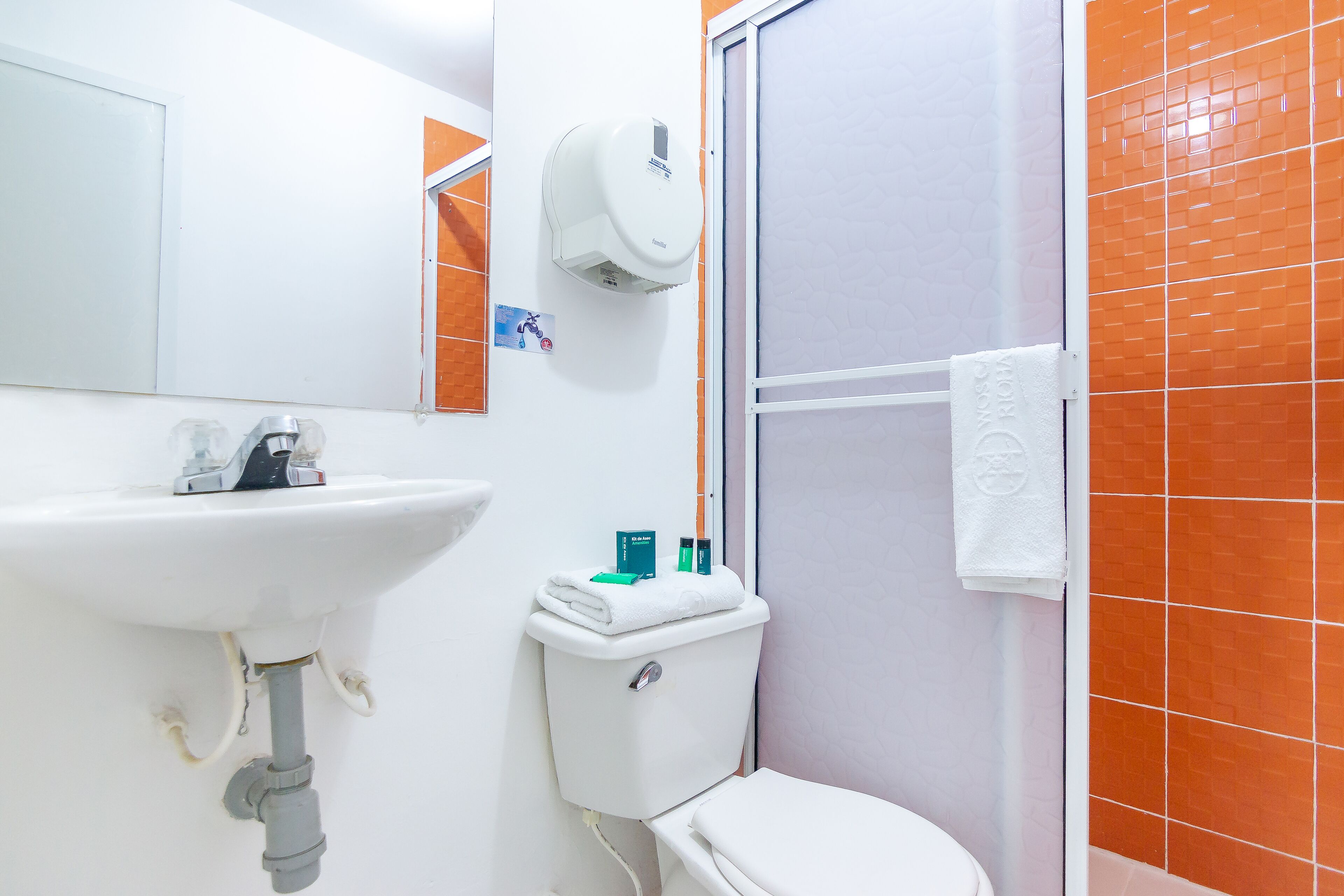 A bathroom with a white sink, toilet, and shower.