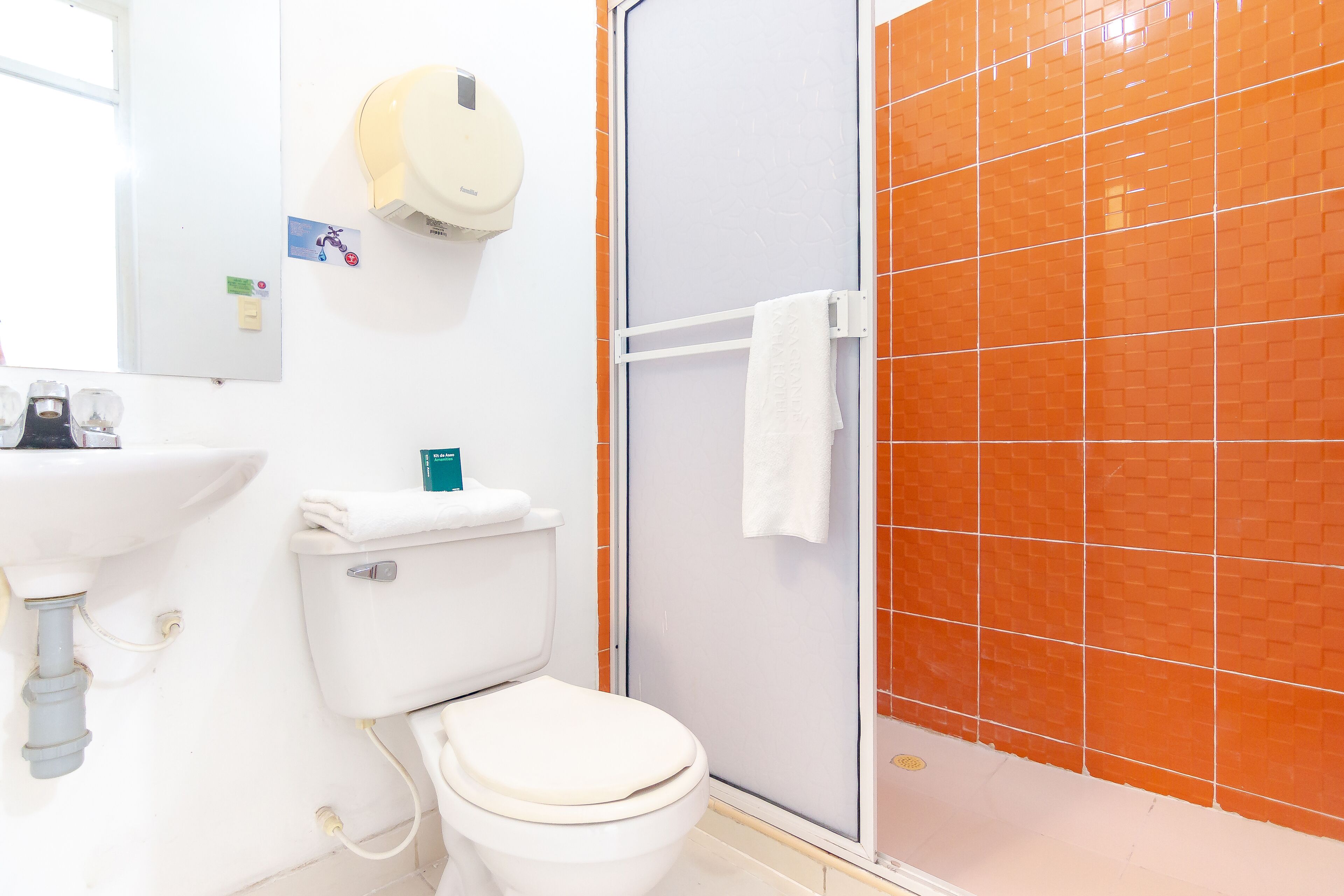 A bathroom with a toilet, sink, and shower.