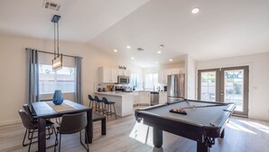 A modern kitchen with white cabinets, a central island, and a pool table. - Scottsdale's Best: Sun, Swing & Gourmet Eats! (Scottsdale)
