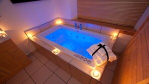 A hot tub with a wooden surround, a towel, and a control panel. - Abhainn Cottage (Isle of Lewis)