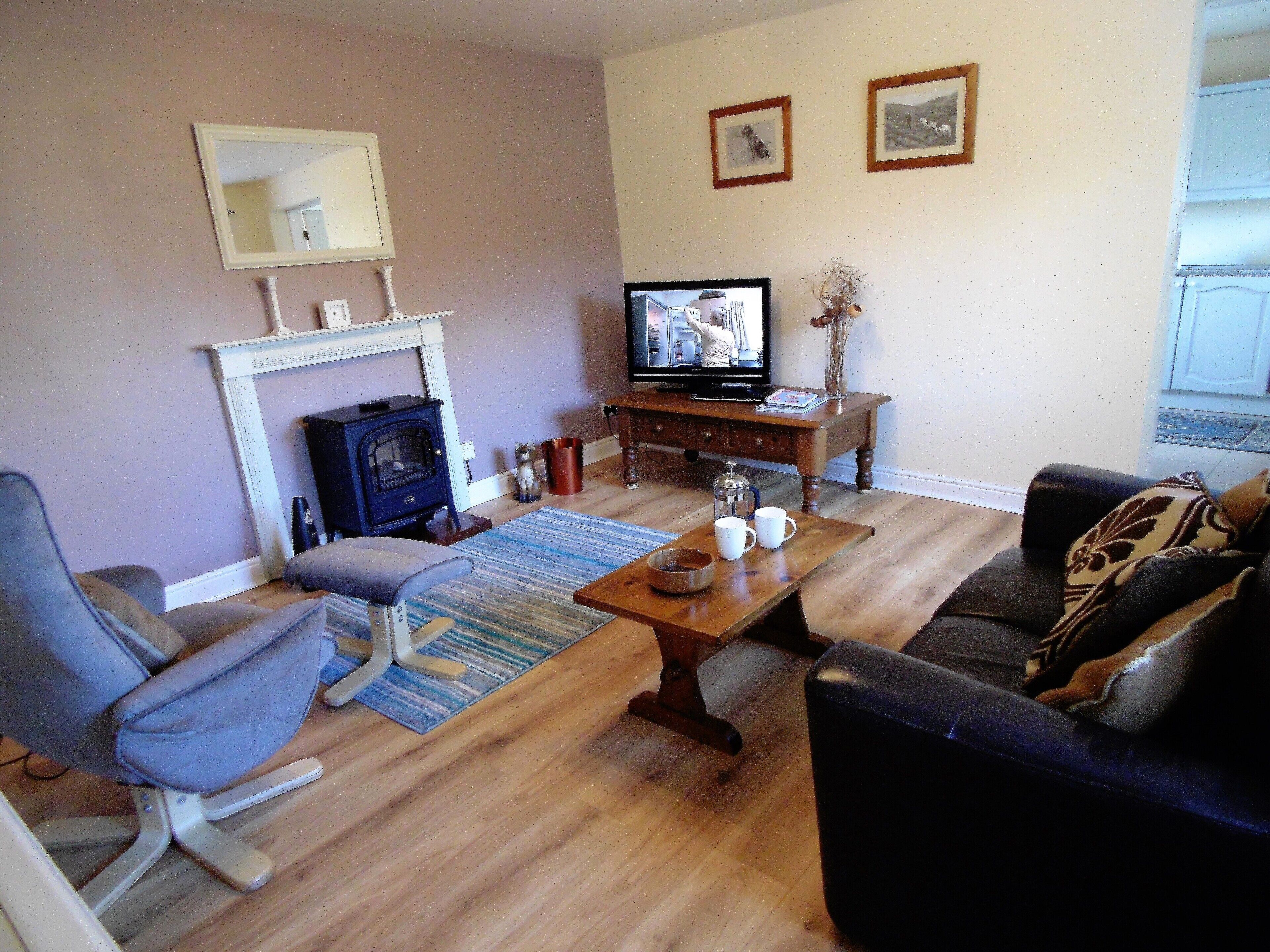 A living room with a fireplace, a television, a sofa, and a coffee table.