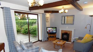 A living room with a fireplace, a television, and two plaid sofas.