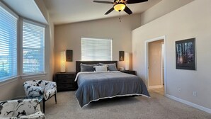 A bedroom with a bed, bedside tables, a chair, a ceiling fan, and a window with blinds. - Relaxing and Inviting Home, 2 Prime Suites, seasonally heated pool on 2.5 acre.  (Atascadero)