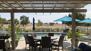 A covered patio with a pool, outdoor furniture, and a grill. - Relaxing and Inviting Home, 2 Prime Suites, seasonally heated pool on 2.5 acre.  (Atascadero)