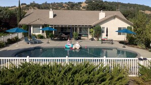 A house with a swimming pool, outdoor furniture, and umbrellas. - Relaxing and Inviting Home, 2 Prime Suites, seasonally heated pool on 2.5 acre.  (Atascadero)