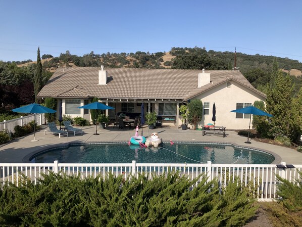 A house with a swimming pool, outdoor furniture, and umbrellas. - Relaxing and Inviting Home, 2 Prime Suites, seasonally heated pool on 2.5 acre. (Atascadero)