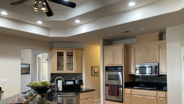 A modern kitchen with wooden cabinets, a black countertop, stainless steel appliances, and a built-in oven. - Relaxing and Inviting Home, 2 Prime Suites, seasonally heated pool on 2.5 acre.  (Atascadero)