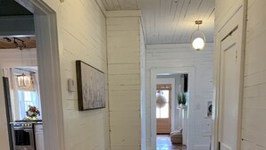 A hallway with wooden floors, white walls, and a hanging light fixture. - Rustic retreat — Car Service Available to& from Oxford, Tunica, Memphis (Sardis)