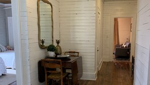 A room with white wooden walls, a dining table with chairs, a mirror, and a rug. - Rustic retreat — Car Service Available to& from Oxford, Tunica, Memphis (Sardis)