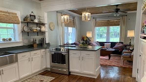 A modern kitchen with white cabinets, a stainless steel range, and a wooden ceiling. - Rustic retreat — Car Service Available to& from Oxford, Tunica, Memphis (Sardis)