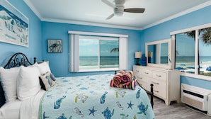 A bedroom with a bed, a dresser, a ceiling fan, and a window with a view of the beach. - Cozy 1BR Condo w/ 0 min walk to beach! Spectacular views! Summer 2026 open! (North Redington Beach)