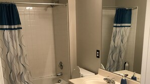 A bathroom with a bathtub, toilet, and two sinks. - Simple Serenity  (Fredericksburg)