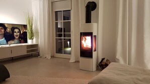 Una sala de estar moderna con un televisor de pantalla plana, una chimenea y un ventanal corredera.