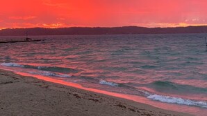 Una playa con olas y un atardecer.
