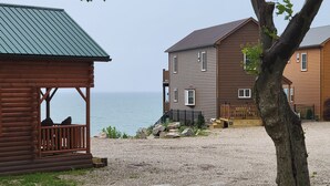 Une cabane en bois avec une véranda et vue sur l’eau.