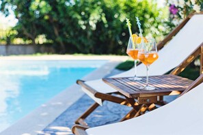 A poolside lounge chair with a glass of orange cocktail and a straw. - Charming 3 bedroom villa with pool surrounded by greenery (Kaštelir)