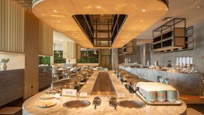 Un buffet avec plusieurs points de service, un comptoir central et un aménagement intérieur moderne.