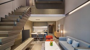 Un intérieur moderne comprenant un escalier, un coin repas et un espace de vie.