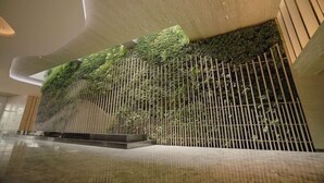 Un intérieur moderne avec un mur végétal vertical, un sol en marbre poli et un design minimaliste.