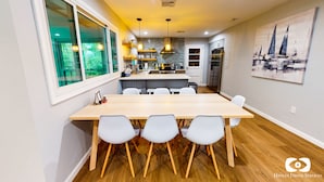 A modern kitchen with a central island, white chairs, and a dining table. - Lakefront Retreat, Renovated, Pet Friendly, Close to All Area Attractions (Pocono Summit)