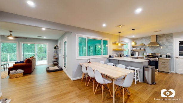 A modern kitchen with a central island, white chairs, and a dining table. - Lakefront Retreat, Renovated, Pet Friendly, Close to All Area Attractions (Pocono Summit)