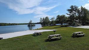 A lakeside park with picnic tables, a playground, and a sandy beach. - Lakefront Retreat, Renovated, Pet Friendly, Close to All Area Attractions (Pocono Summit)