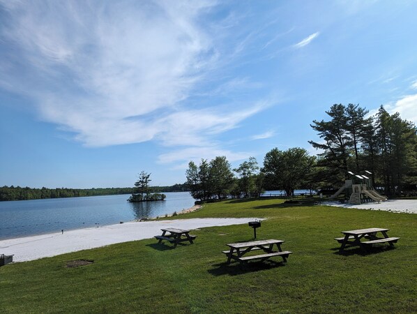 A lakeside park with picnic tables, a playground, and a sandy beach. - Lakefront Retreat, Renovated, Pet Friendly, Close to All Area Attractions (Pocono Summit)