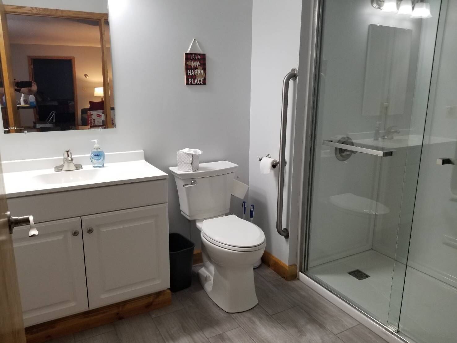 Un bany modern amb vàter, rentamig i dutxera amb envàs de vidre.