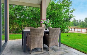 Relax in a serene outdoor space with a table, two chairs, and lush greenery.