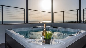 A hot tub with a bottle of champagne and two glasses on a balcony overlooking the sea. - Luxurious home in Lun with sauna (Lun)