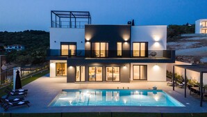 A modern two-story house with a swimming pool, large windows, and outdoor seating. - Luxurious home in Lun with sauna (Lun)